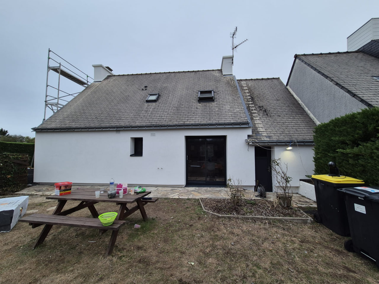 Chantier dans le Morbihan — façade arrière finie enduit blanc, vue depuis le jardin
